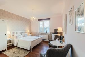 een slaapkamer met een bed, een tafel en stoelen bij Hotel Villa Wahnfried Thiessow in Thiessow