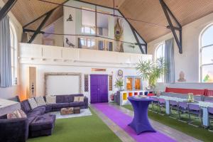 a living room with purple furniture and a purple door at LOFT Groepsaccommodatie in Boxum