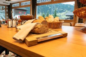a table with a basket of bread on a table at Basic Rooms Jungfrau Lodge in Grindelwald +12 photos