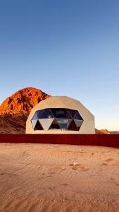 a dome building in the desert with a mountain in the background at Tariq Camp Wadi Rum in Wadi Rum +12 photos