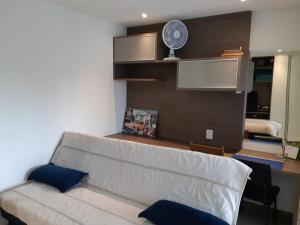 a living room with a couch and a fan at Kitnet acolhedora in Caxias do Sul