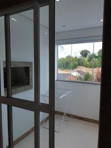 a room with a glass door with a window at Kitnet acolhedora in Caxias do Sul