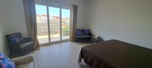 a bedroom with a bed and a large window at Fort Apartments in Vila do Porto