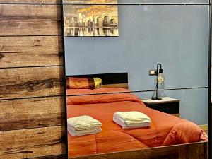 a bedroom with a bed with orange sheets and a mirror at Relax Home Holiday in Panicale +37 photos