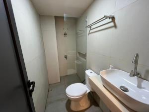 een badkamer met een wit toilet en een wastafel bij INSAHAUS Guest House in Kotalama
