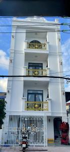 a white building with a balcony and a motorcycle parked in front at LAKSHMI Apartment & Hotel Da Nang in Danang