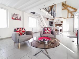 een woonkamer met twee stoelen en een tafel bij Gîte de la Petite Forge in Clévilliers +22 foto's