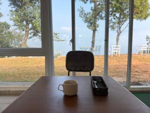 een kopje koffie op een tafel voor een stoel bij Begnas horizon in Pokhara