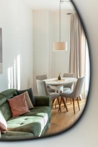 a living room with a green couch and a table at The Dream Getaway SkyLine by DeVasco in Bečići