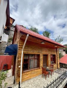 a wooden house with a table and chairs in front of it at Isgobya Sumela Monastery 104 in Macka
