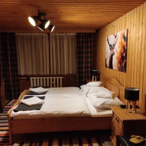 a bedroom with a bed and a painting on the wall at Pod Limbą in Jurgów +24 photos