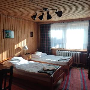 a bedroom with two twin beds and a window at Pod Limbą in Jurgów