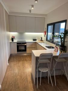 a kitchen with white cabinets and a table and chairs at Apartamento T2 - Leiria in Leiria