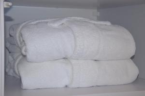 een stapel witte handdoeken op een plank bij Spokojnia in Lubrza