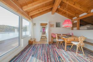een eetkamer met een tafel en stoelen en een groot raam bij Hotel Haus am Waldrand in Flims