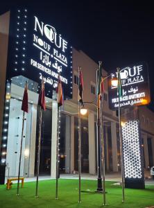 a building with flags and signs in front of it at نوف بلازا nouf plaza for serviced apartments in Ad Dawādimī