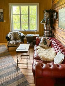 un soggiorno con un divano in pelle e un tavolo di Timmerhus Med Bastu Vid Ljungan a Sundsvall