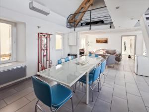 een eetkamer met een witte tafel en blauwe stoelen bij Gîte de la Petite Forge in Clévilliers