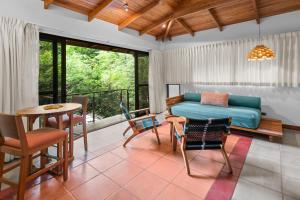 a living room with a couch and a table and chairs at Olas Verdes Hotel in Nosara