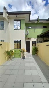 une grande maison blanche et verte avec une cour dans l'établissement AL KHOURY Staycation, à Tanza