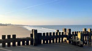 a wooden fence on a beach next to the ocean at Seafields Chalet in Walcott