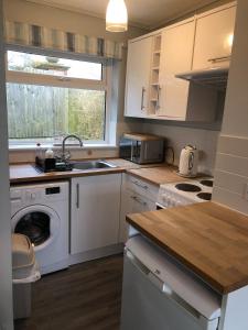 a kitchen with a washing machine and a sink at Seafields Chalet in Walcott