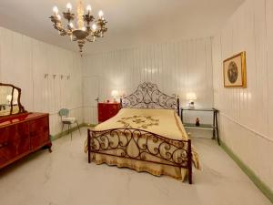 een slaapkamer met een bed en een kroonluchter bij L'ENCANTO DE LUNA -Una Casa Autentica Comacchiese in Comacchio