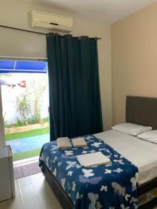 a bedroom with a bed and a window with a pool at Mar & Mar Suites in Arraial do Cabo