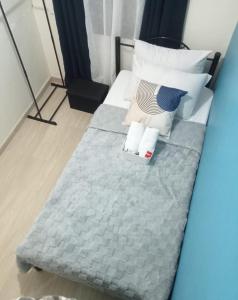 un lit avec deux oreillers et une couverture bleue dans l'établissement AL KHOURY Staycation, à Tanza