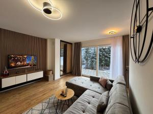 a living room with a couch and a tv at GO Jahorina by Olympic Gardens in Jahorina