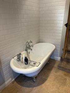 a bath tub in a white bathroom with at 2 Bed Terrace Cottage with Cathedral Views in Salisbury