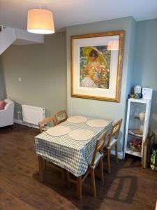 a dining room table with chairs and a painting on the wall at 2 Bed Terrace Cottage with Cathedral Views in Salisbury +3 photos