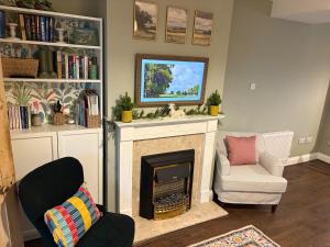 a living room with a fireplace and a chair at 2 Bed Terrace Cottage with Cathedral Views in Salisbury