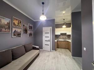 a living room with a couch and a kitchen at Апартаменти Площа Ринок in Lviv