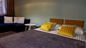een slaapkamer met een bed met twee gele kussens bij Apartament Granatowy Chill in Łódź