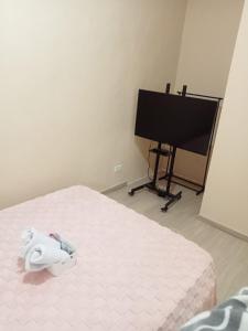 une chambre avec un lit et une télévision à écran plat dans l'établissement AL KHOURY Staycation, à Tanza 1 autre photo