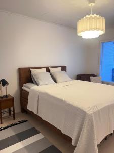 een slaapkamer met een bed met witte lakens en een raam bij Villa Blacksmith in Rovaniemi