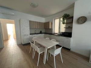 une cuisine avec une table et des chaises dans une pièce dans l'établissement Home far from home, à Castelnuovo del Garda