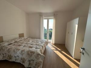 une chambre avec un lit et une grande fenêtre dans l'établissement Home far from home, à Castelnuovo del Garda