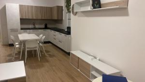 une cuisine avec des armoires blanches et une table et des chaises dans l'établissement Home far from home, à Castelnuovo del Garda 6 autres photos