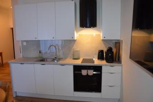 een keuken met witte kasten en een spoelbak bij Spokojnia in Lubrza