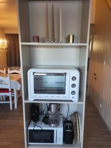 a microwave and a coffee maker on a shelf at Cocoon Ny II - DURBUY in Hotton