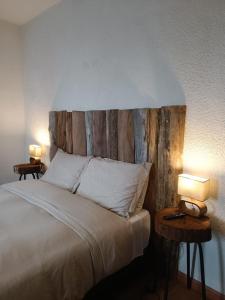 une chambre avec un lit avec une tête de lit en bois dans l'établissement Hacienda El Castillo Hotel Boutique, à Pasto