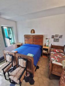 een slaapkamer met een blauw bed en twee stoelen bij Casa di Bimba in Quarto