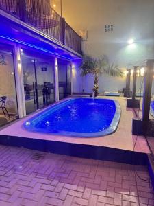 a large blue swimming pool in a building at Hotel Mais Lazer - Hotel & Spa in Joinville