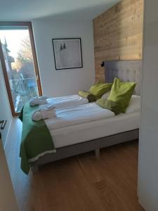 a bedroom with a large bed with green pillows at Traum in Zell am See mit Badeplatz in Erlberg