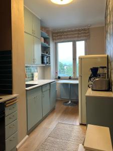 a kitchen with mint green cabinets and a window at ArtBeat Downtown in Turku
