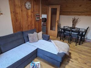 a living room with a blue couch and a dining room at Planinska Kućica in Mostar