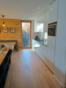 a kitchen with white appliances and a wooden floor at Traum in Zell am See mit Badeplatz in Erlberg