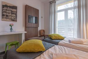 een hotelkamer met twee bedden en een raam bij Boży Dar in Krynica Zdrój